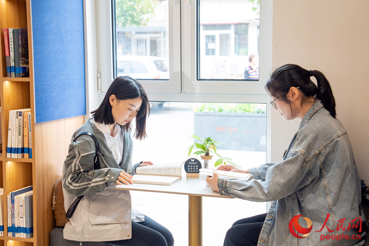 在靖江东里书吧,两位年轻的居民在享受安静的阅读时光。人民网记者 孙翼飞摄