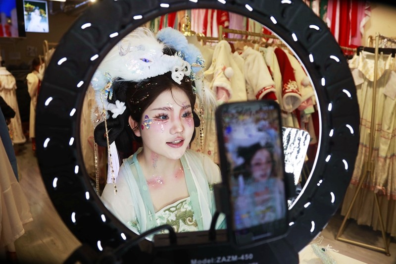 在河南省洛阳市一家汉服店里，一位头戴龙形头饰的主播在推广汉服文化。人民网记者 慎志远摄