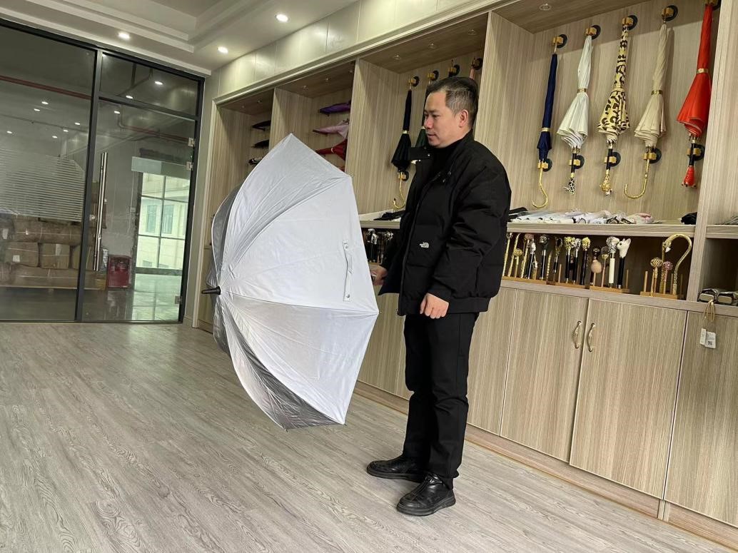 在浙江省绍兴市上虞区的一家制伞厂里，雷鹏琳展示根据网友留言设计的镭射反光伞。人民网记者 王丽玮摄